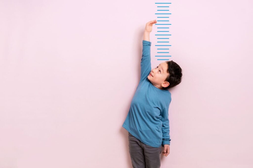 New to Investing? Start With This Canadian Dividend Stock Child measures his height on wall. He is growing taller.