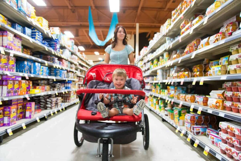 An Ideal TFSA Stock for Retirees, Paying 5.2% Each Month A woman shops in a grocery store while pushing a stroller with a child