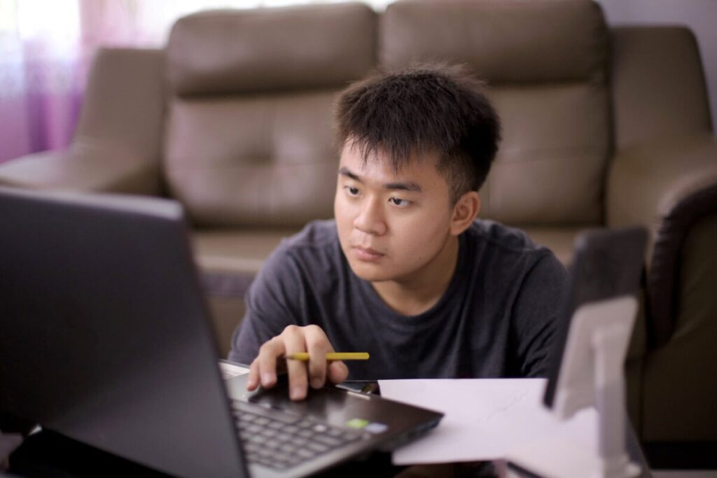 Opening Your First Investing Account in Canada: What to Know Before You Click “Apply” Young adult concentrates on laptop screen